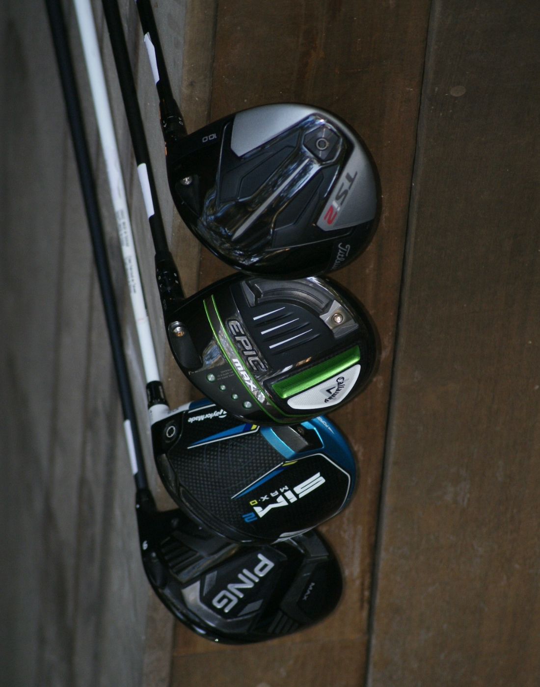 4 Name brand drivers up against a brown wood background